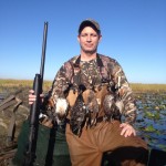 Man_standing_on_airbot_with_shotgun_in_everglades_duck_hunting
